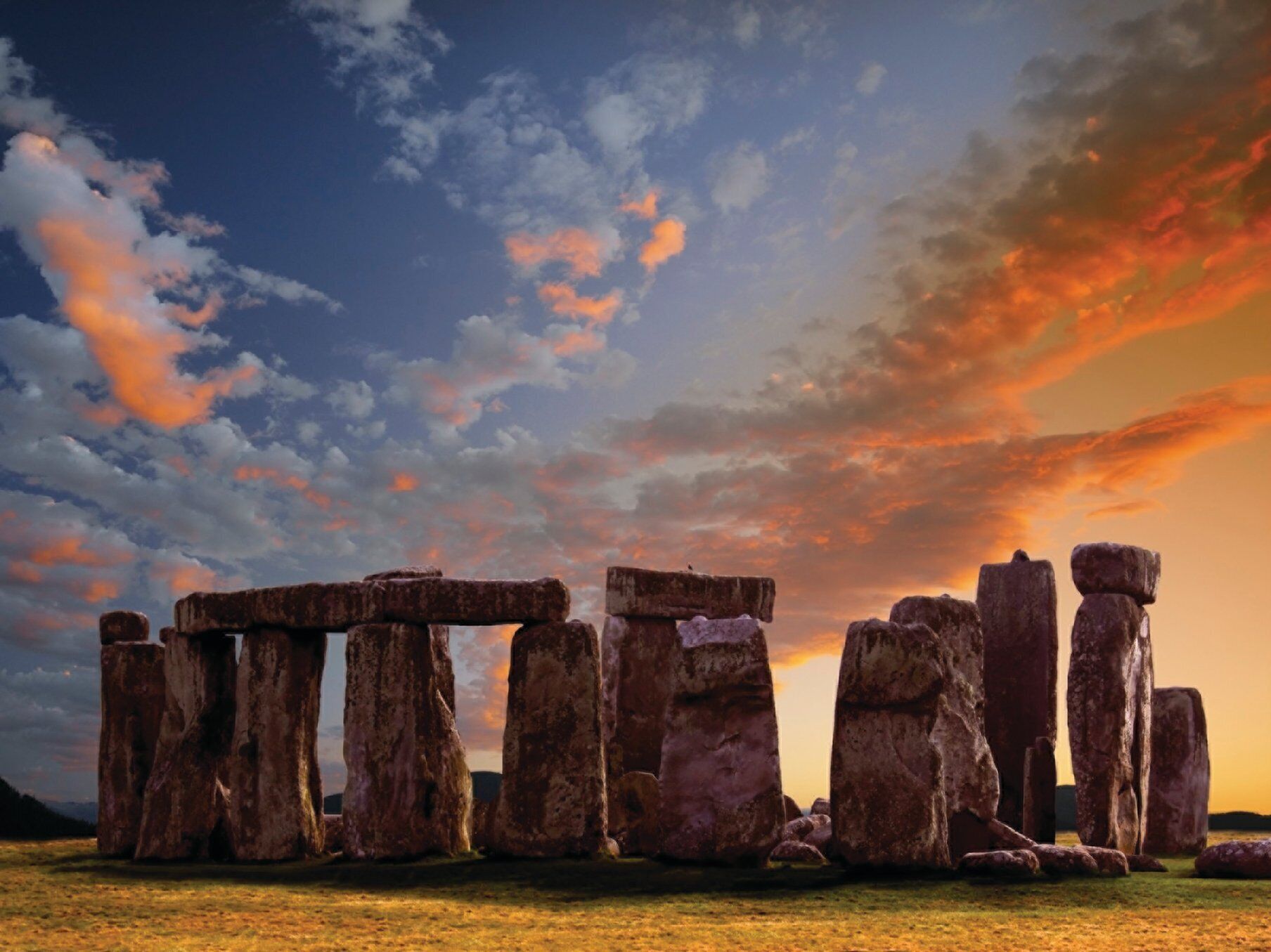 Stonehenge en un campo bajo un cielo al atardecer.
