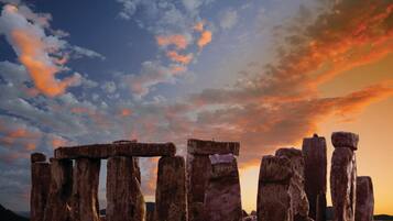 Stonehenge en un campo bajo un cielo al atardecer.