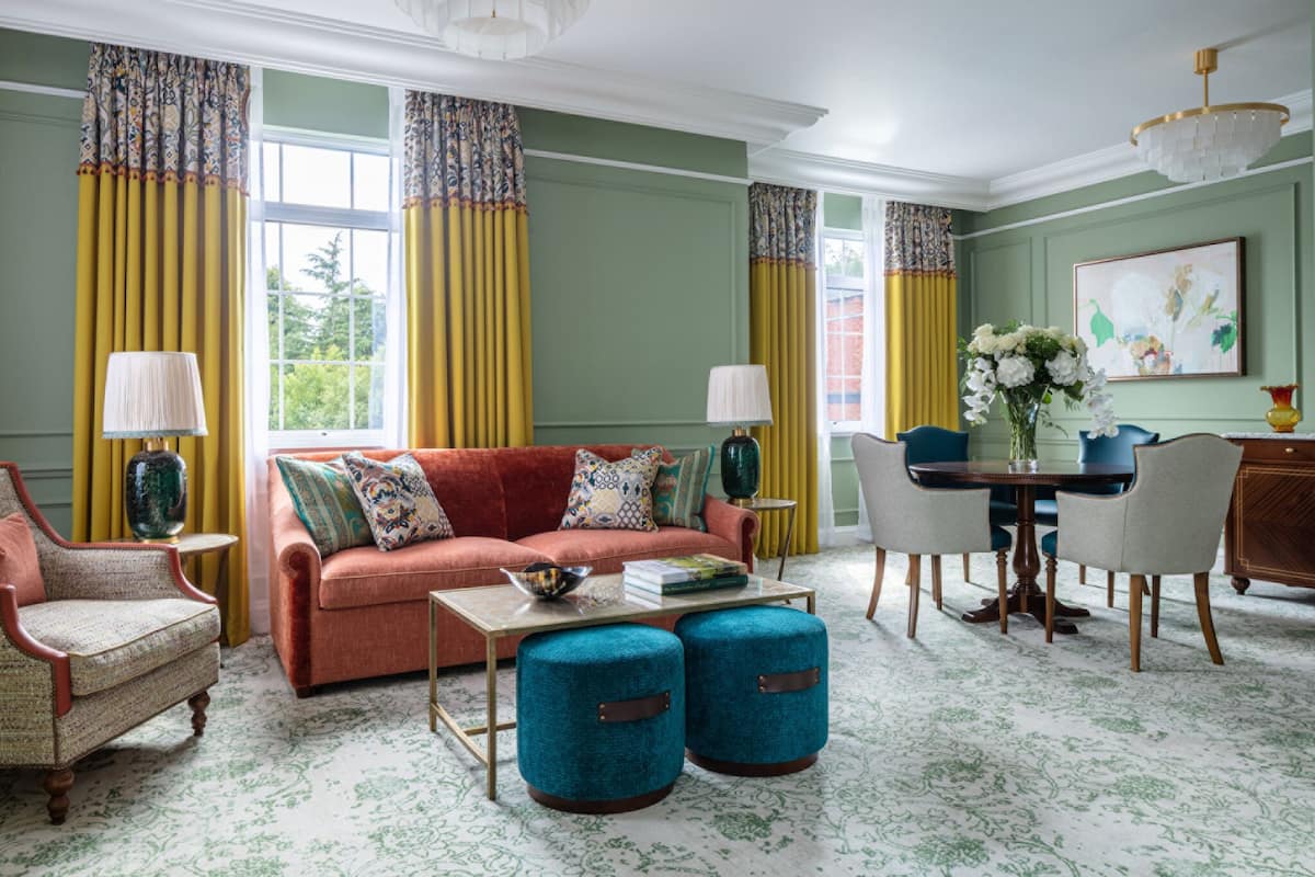 A living room with a sofa, armchairs, a coffee table, and a dining table with chairs.