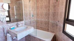 A bathroom with a marble sink, a glass shower enclosure, and a large mirror. - BLUESEA Costa Serena (Torremolinos)