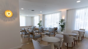 A modern hotel room with a seating area, a dining table, and large windows with sheer curtains. - BLUESEA Costa Serena (Torremolinos)
