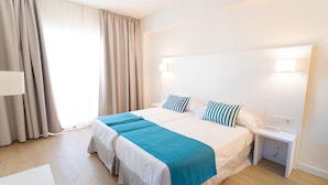 A hotel room with a large bed, two bedside tables, a nightstand, a lamp, and a window with curtains. - BLUESEA Costa Serena (Torremolinos)