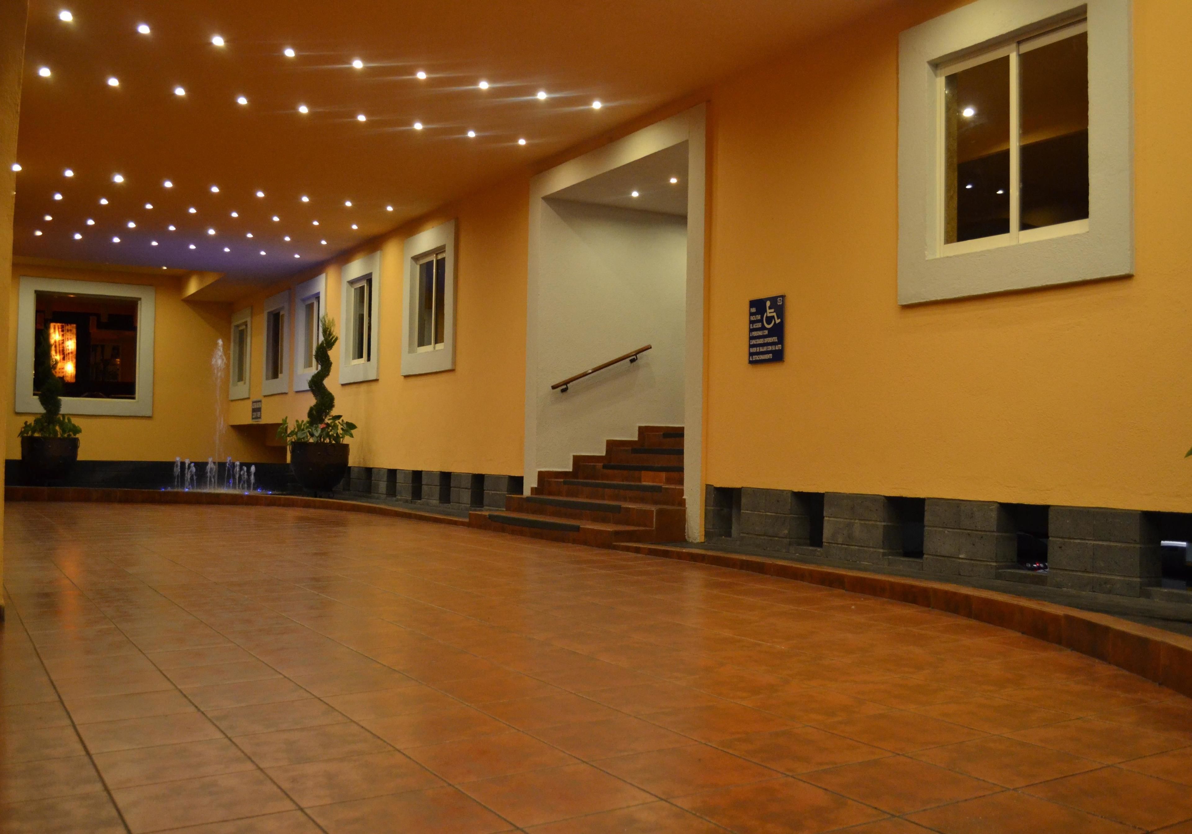 En rymlig entréhall med ett klinkergolv, en trappa och ett trappräcke.