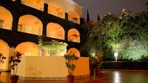 A building with multiple arches and balconies, a fountain, and potted plants. - Hotel Misión Orizaba (Orizaba)