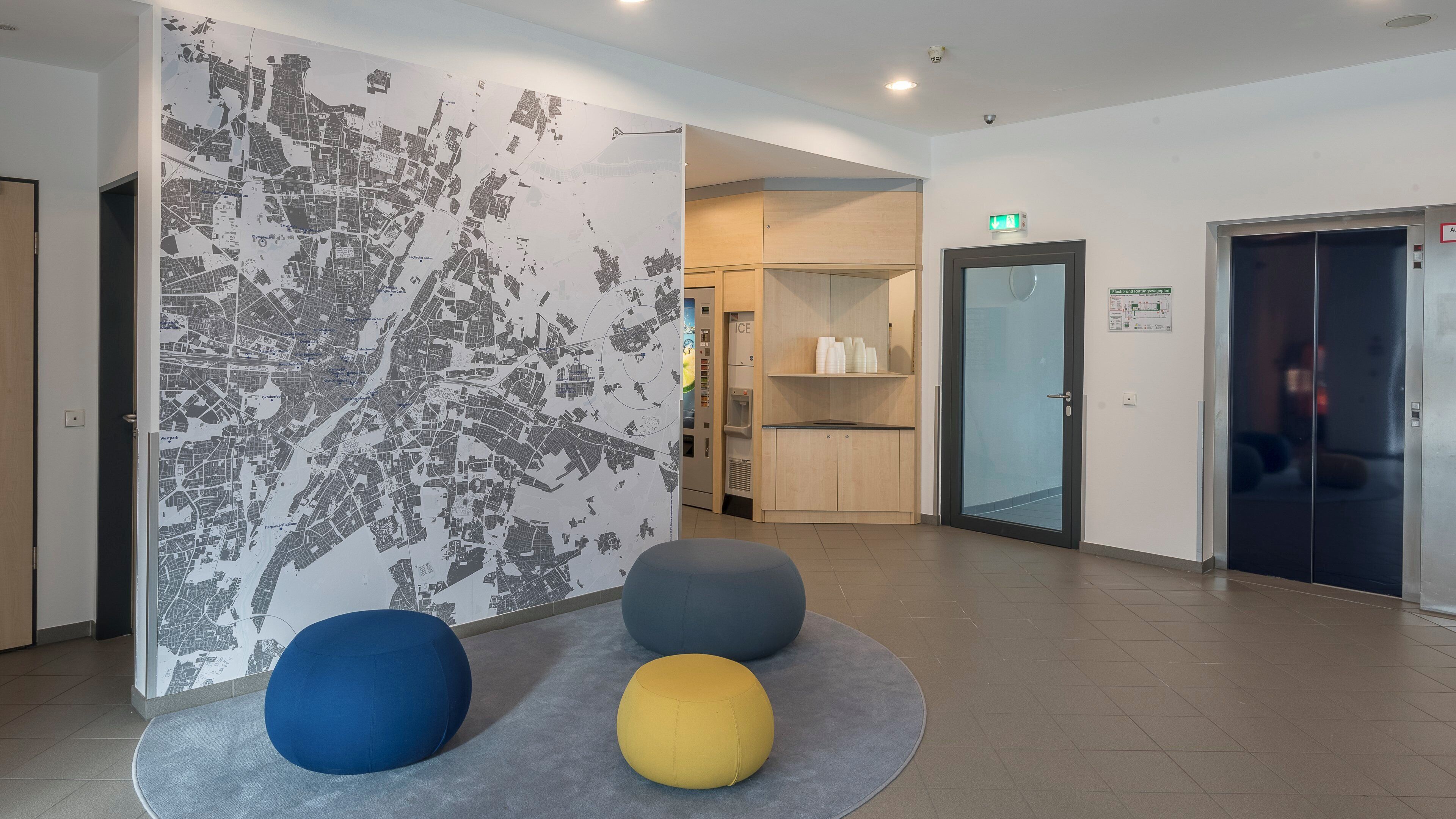 A lobby with a map wall, a vending machine, and a glass door.