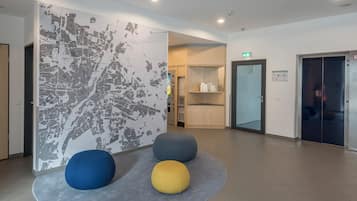 A lobby with a map wall, a vending machine, and a glass door.