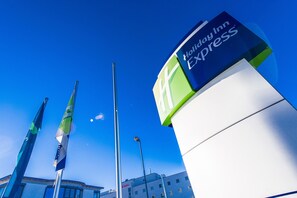 A Holiday Inn Express sign with a clear blue sky in the background. - Holiday Inn Express München-Messe by IHG (Feldkirchen)