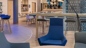 Un área de bar moderna con taburetes altos, una mesa de billar y una barra.