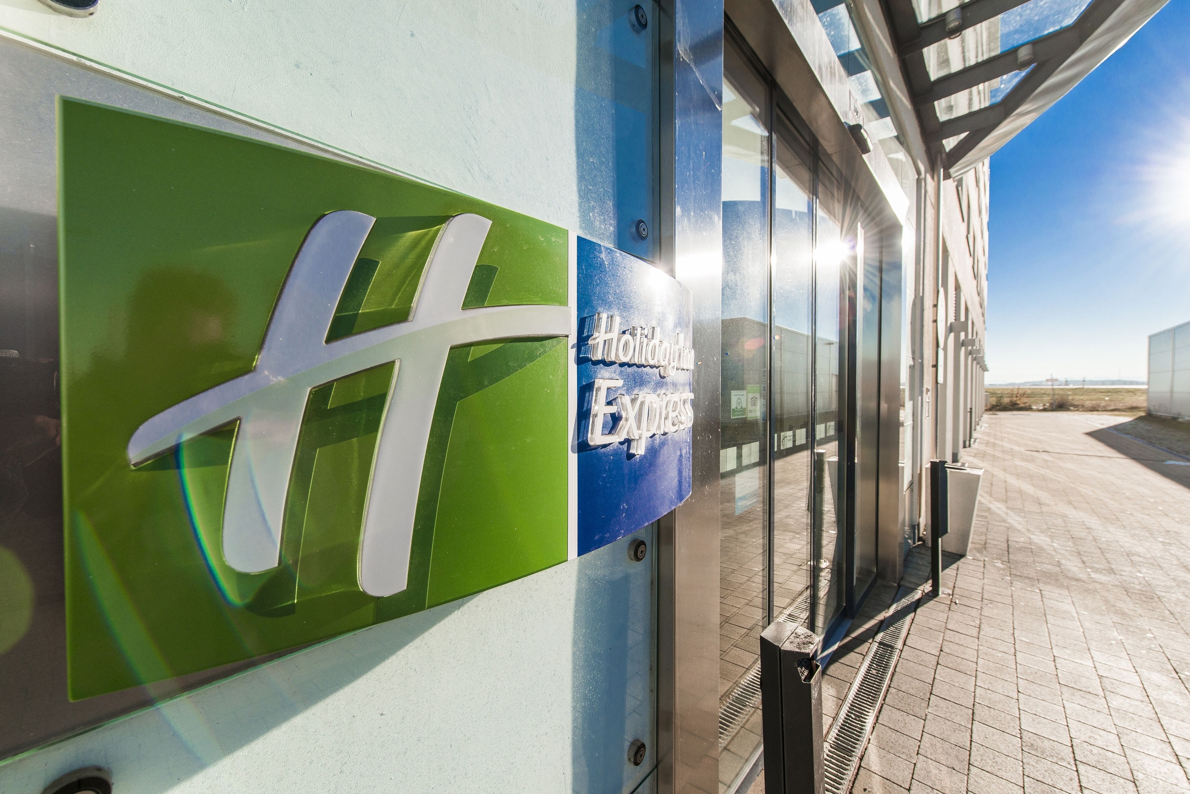 Ein Gebäude mit Glasfassade und einem Schild mit der Aufschrift 'Holiday Inn Express'.