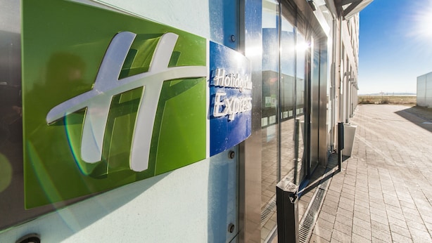 Un edificio con fachada de vidrio y un letrero que dice "Holiday Inn Express".