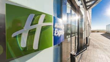 Un bâtiment doté d’une façade en verre et d’une enseigne indiquant « Holiday Inn Express ».