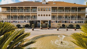 Un hotel con patio central, varios balcones y una fuente.