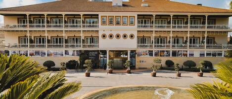 A hotel with a central courtyard, multiple balconies, and a fountain.