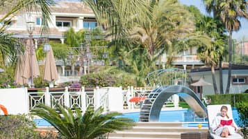 Una piscina cubierta, una piscina al aire libre, sombrillas, tumbonas