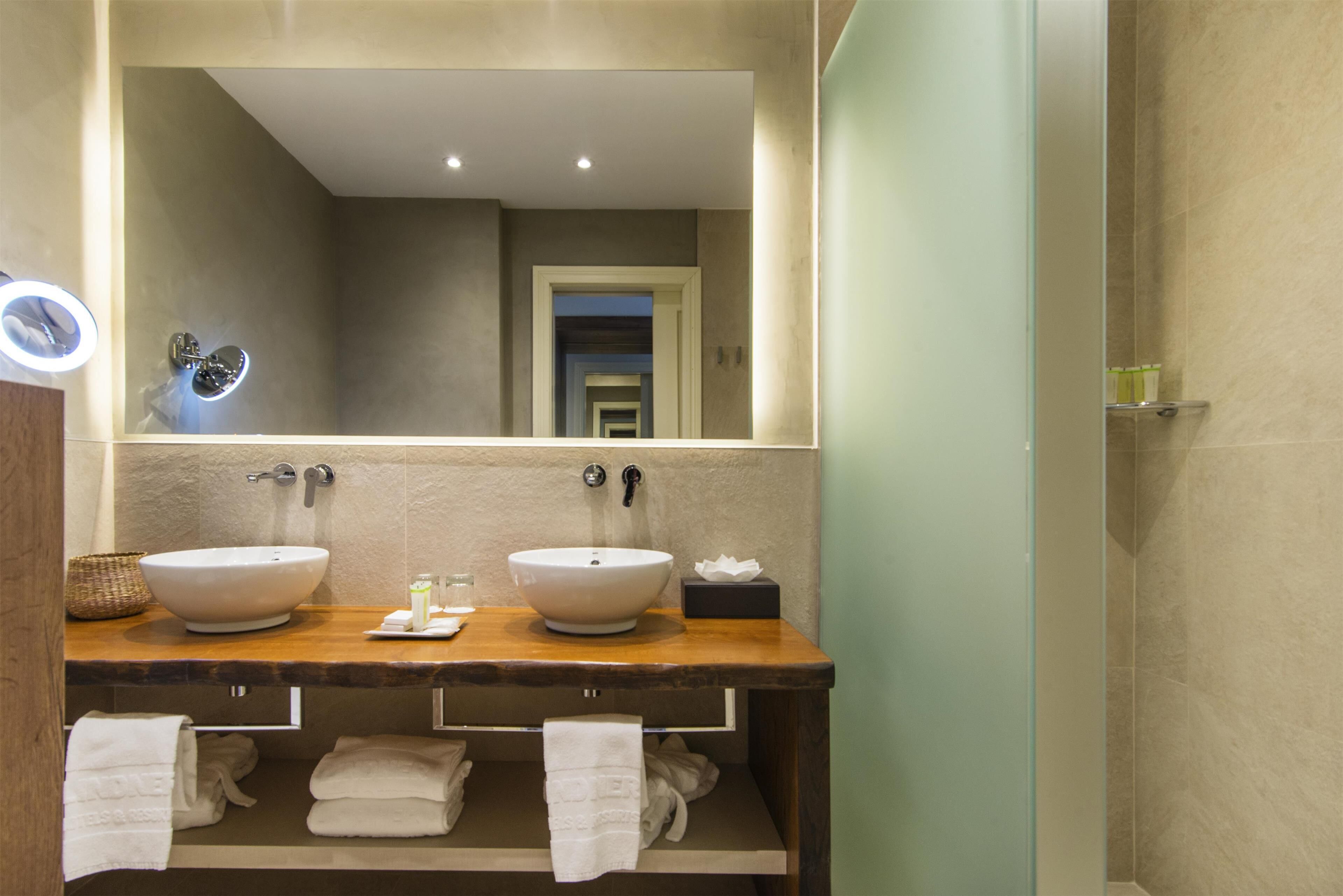 A bathroom with two sinks, a mirror, and a towel rack.