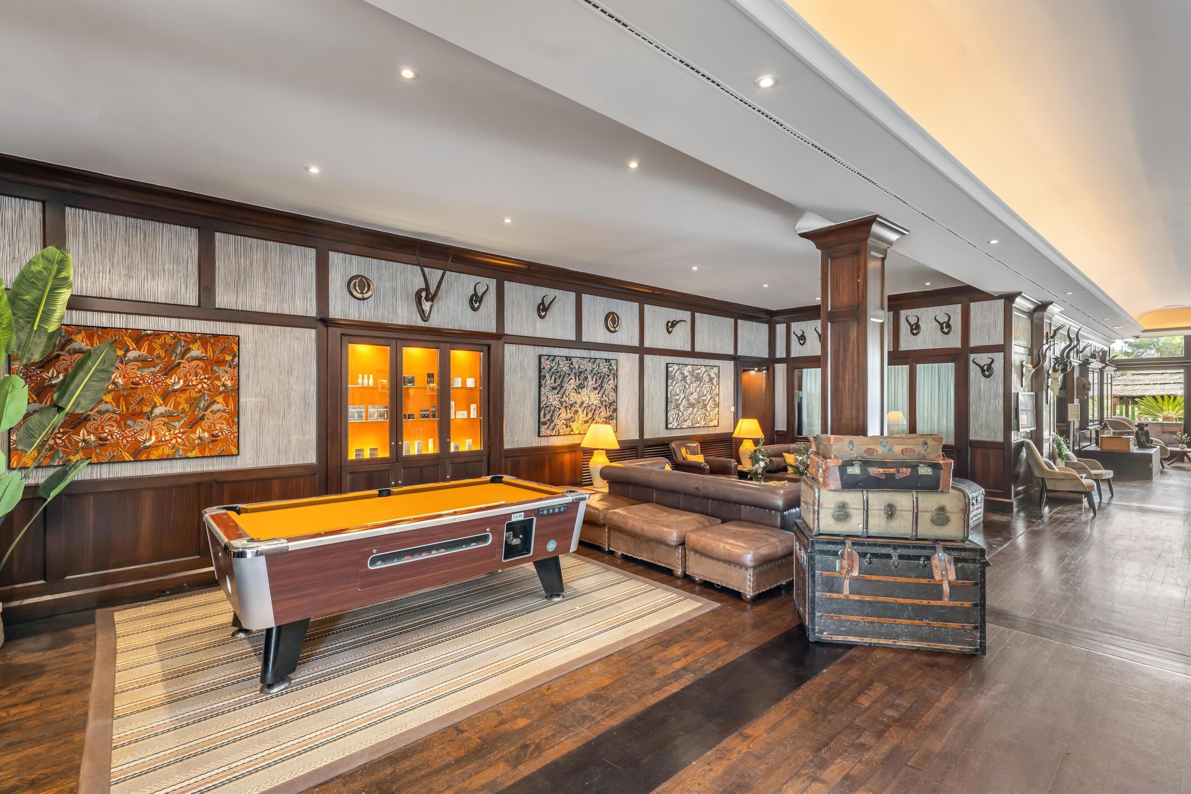 A spacious lobby with a pool table, leather sofas, and a variety of wall art.
