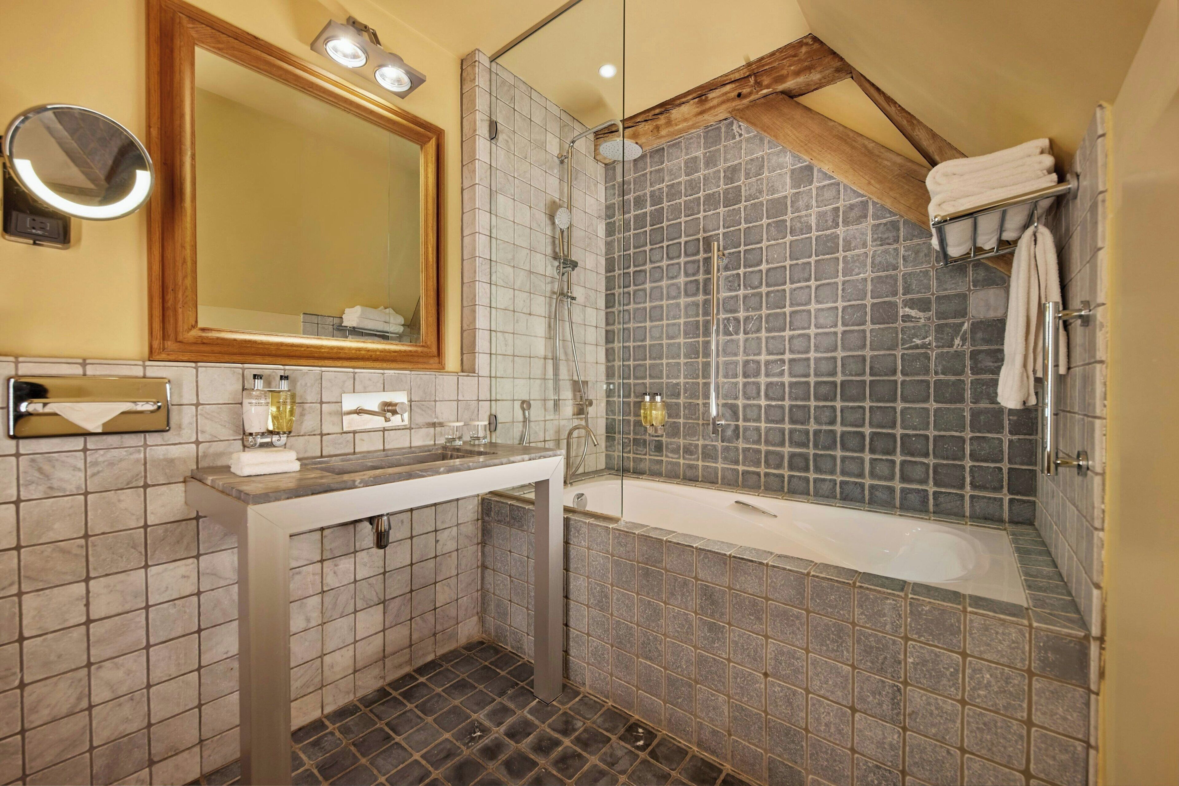 Une salle de bain avec un lavabo, un miroir et une douche.