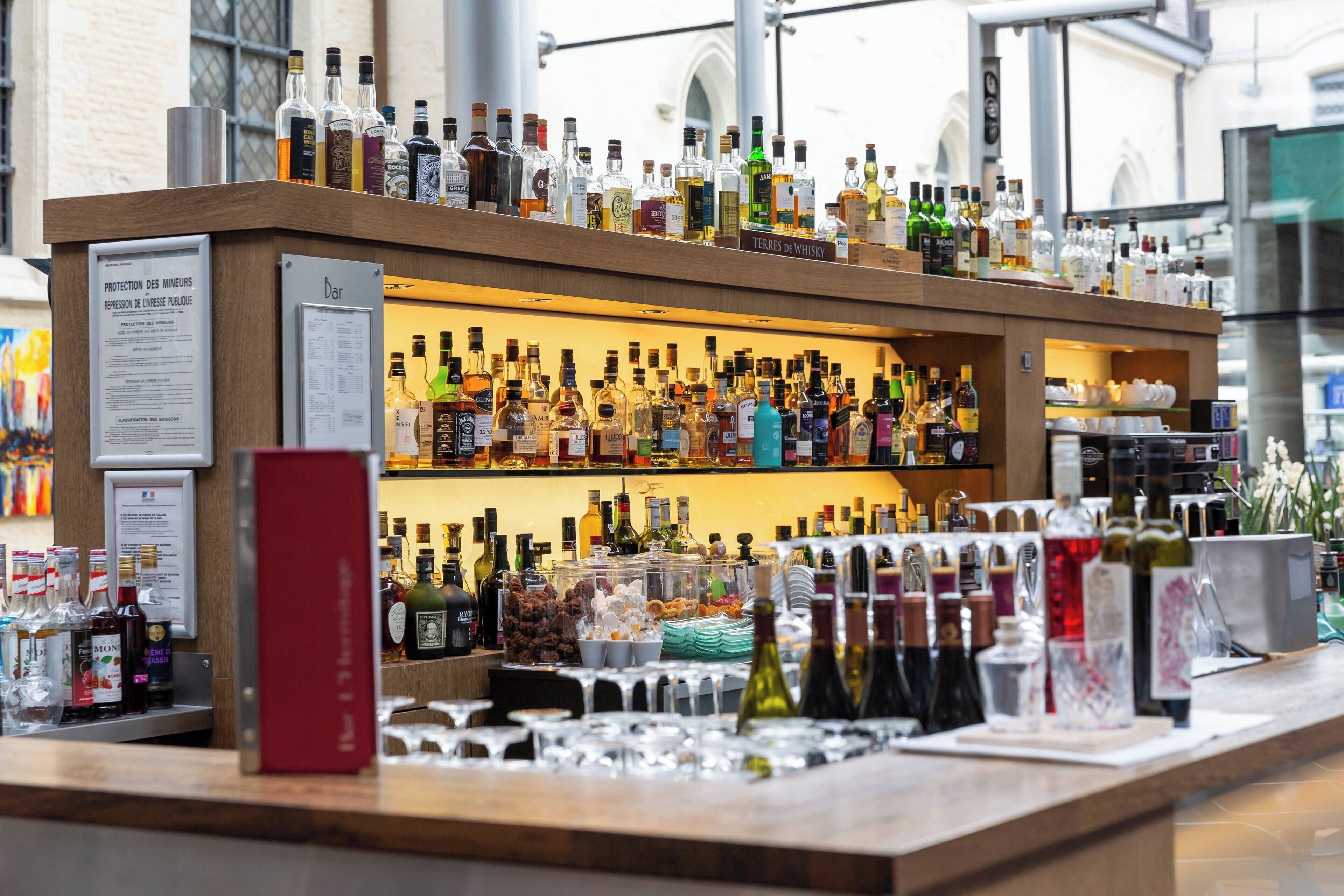 Een bar met verschillende drankflessen en glazen.