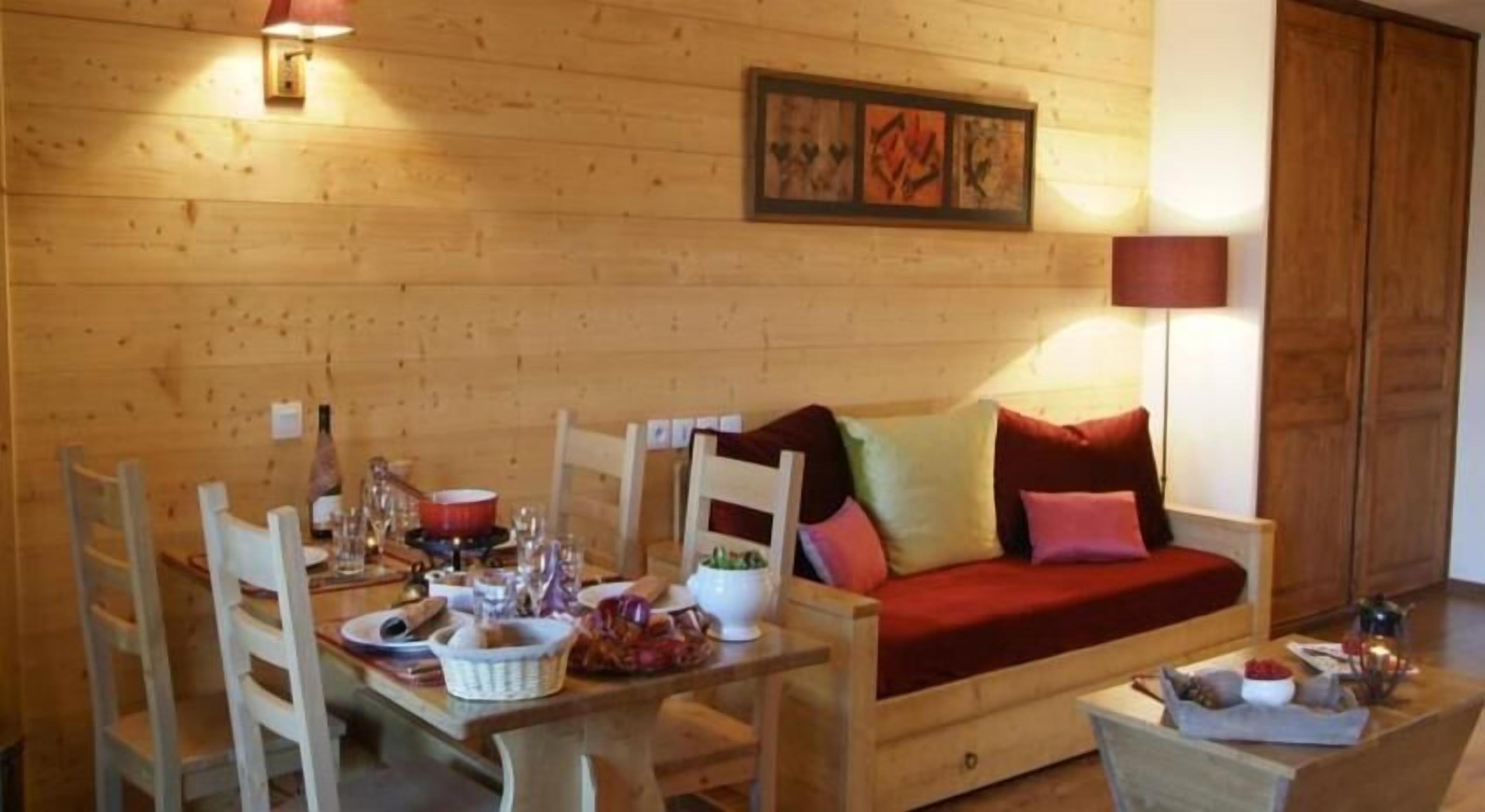 Un intérieur en bois comprenant une table à manger, des chaises, un canapé et une lampe.