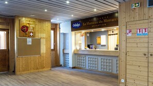 Un espace d’accueil avec un lambris en bois, un comptoir de réception et une enseigne indiquant « Odals ».