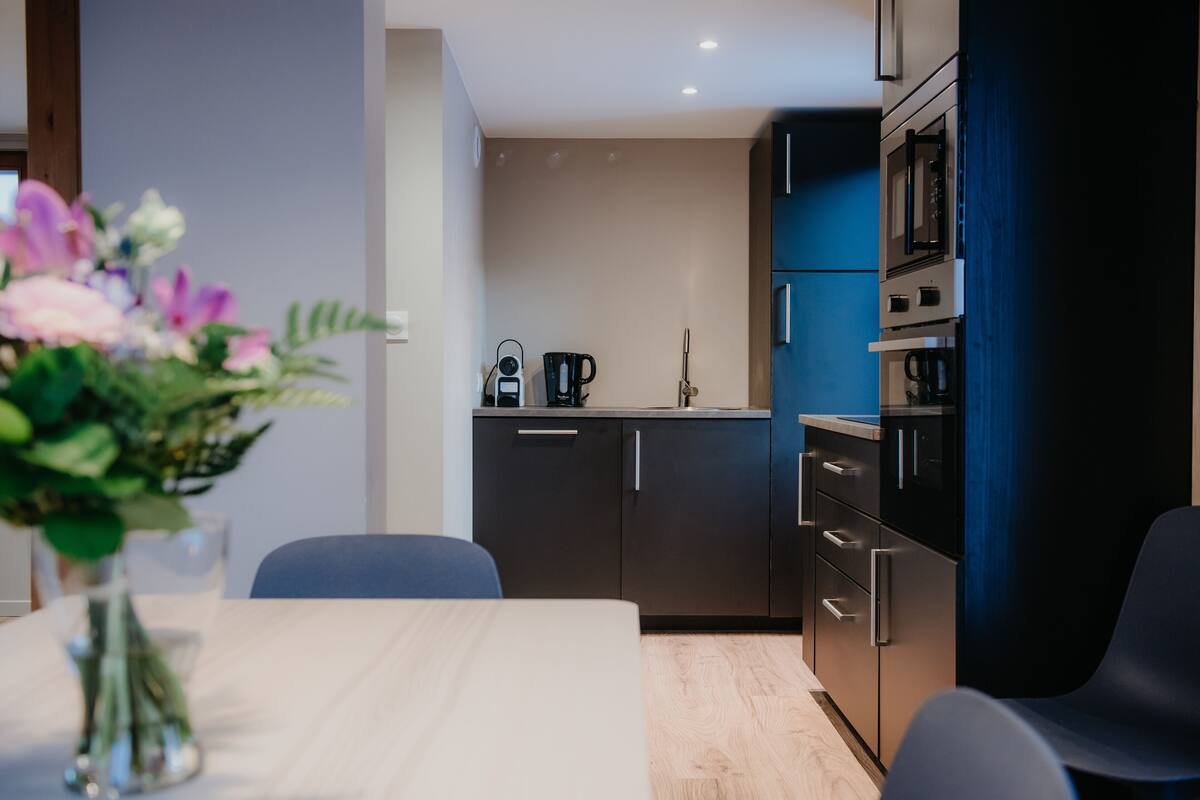 A modern kitchen with dark cabinets, a microwave, and a coffee maker.
