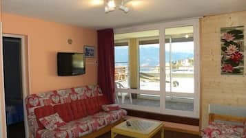 Departamento superior, 1 habitación | Área de sala de estar | Televisión de pantalla plana