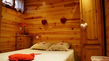 Cozy bedroom with a neatly made bed, bedside table, and wooden wardrobe.