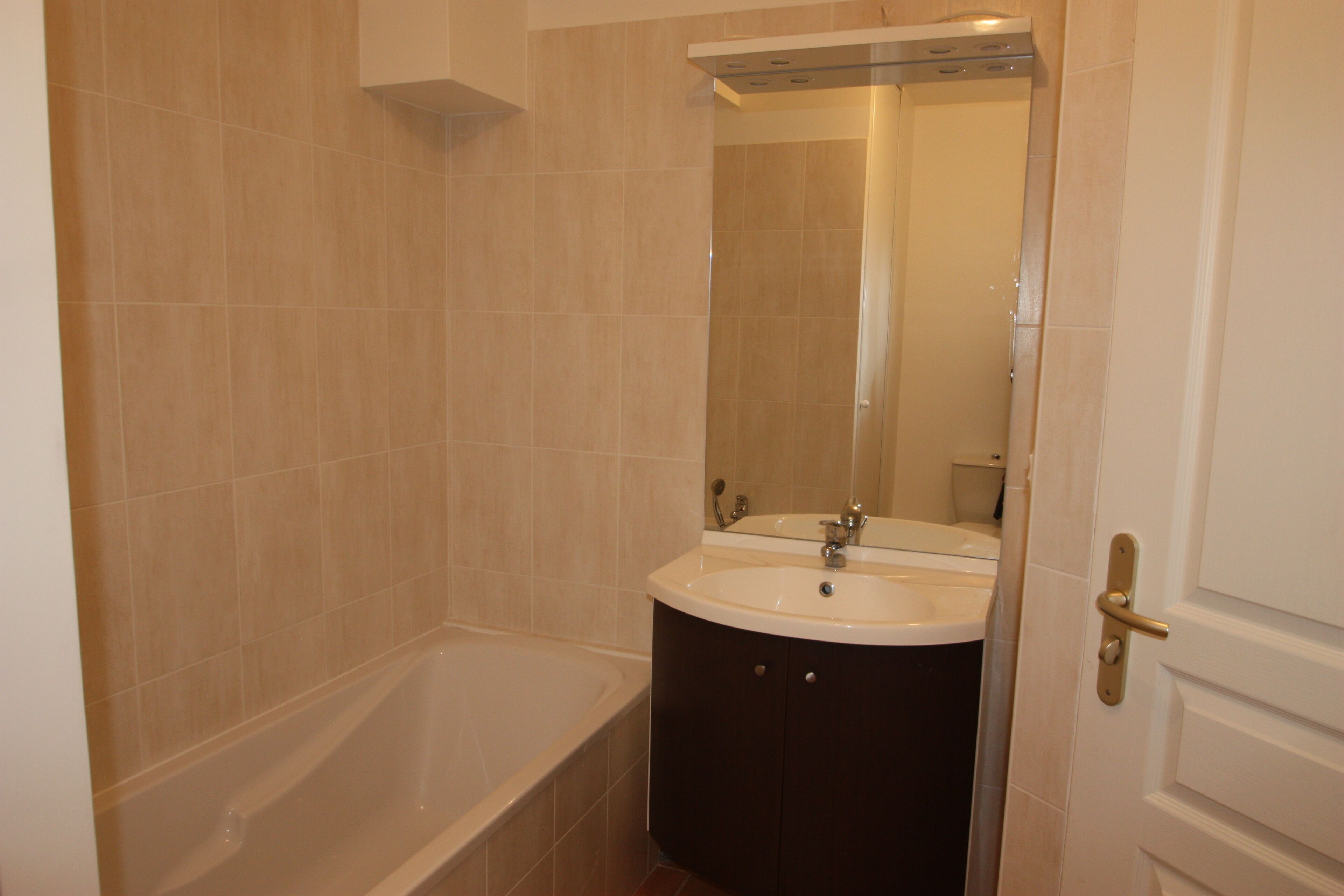 A bathroom with a bathtub, two sinks, and a mirror.