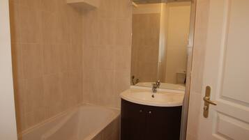 A bathroom with a bathtub, two sinks, and a mirror.