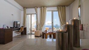 Habitación de hotel moderna con escritorio, silla y vista al mar.
