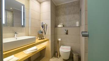Un baño moderno con un lavamanos grande, un espejo y un inodoro.
