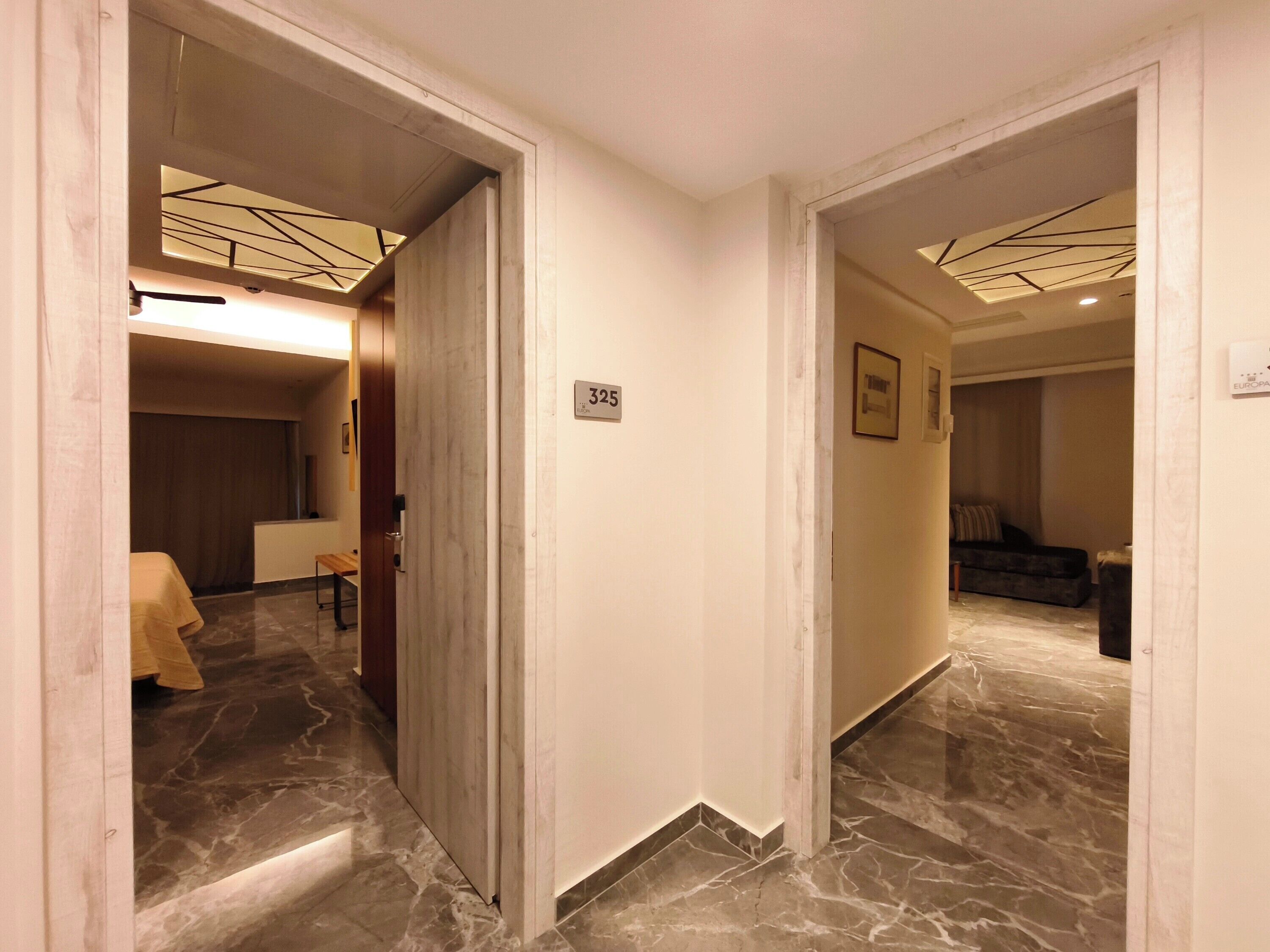Ein Hotelgang mit Marmorboden, einer Rezeption und einer Sitzecke.