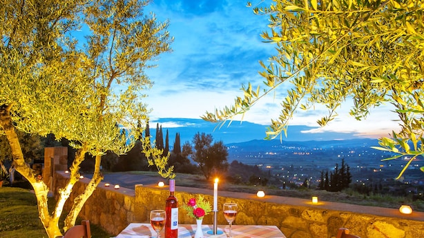 Une table à manger en plein air offrant une vue sur le paysage urbain au crépuscule.