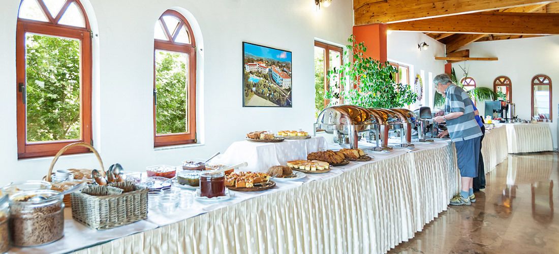 Un buffet con diversi cibi e una persona che serve.
