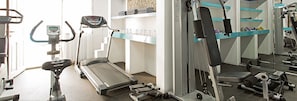 A gym with treadmills, an elliptical, and weight machines. - Kamari Beach Hotel (Santorini)