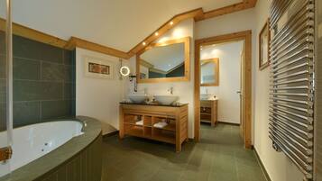 Une salle de bain avec une baignoire sur pieds, un meuble-lavabo et un grand miroir.
