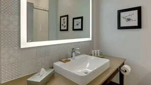 A modern bathroom with a large mirror, a white sink, and two framed pictures on the wall. - Country Inn & Suites by Radisson, Stone Mountain, GA (Stone Mountain)