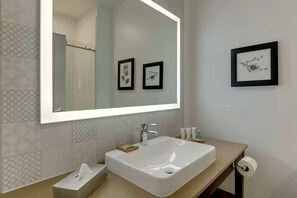 A modern bathroom with a large mirror, a white sink, and two framed pictures on the wall. - Country Inn & Suites by Radisson, Stone Mountain, GA (Stone Mountain)