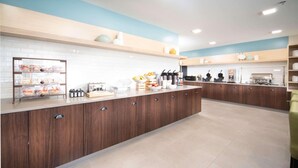 A modern kitchen with wooden cabinets, a white countertop, and various kitchen appliances. - Country Inn & Suites by Radisson, Stone Mountain, GA (Stone Mountain)