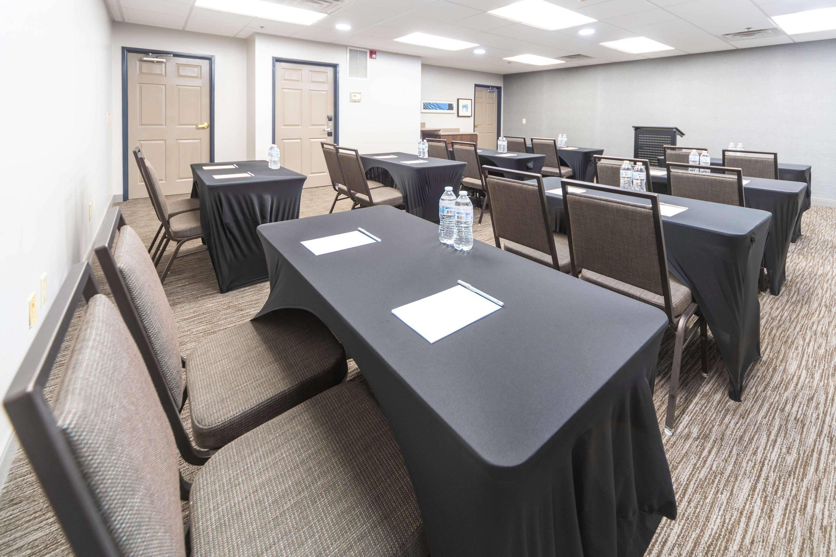 A conference room with tables, chairs, and water bottles.