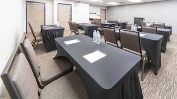 A conference room with tables, chairs, and water bottles.
