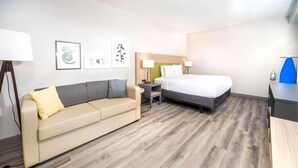A hotel room with a bed, a sofa, a desk, and a lamp. - Country Inn & Suites by Radisson, Stone Mountain, GA (Stone Mountain)