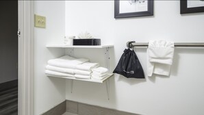 A bathroom with a white sink, a towel rack with folded towels, and a black bag hanging on the towel rack. - Country Inn & Suites by Radisson, Stone Mountain, GA (Stone Mountain)