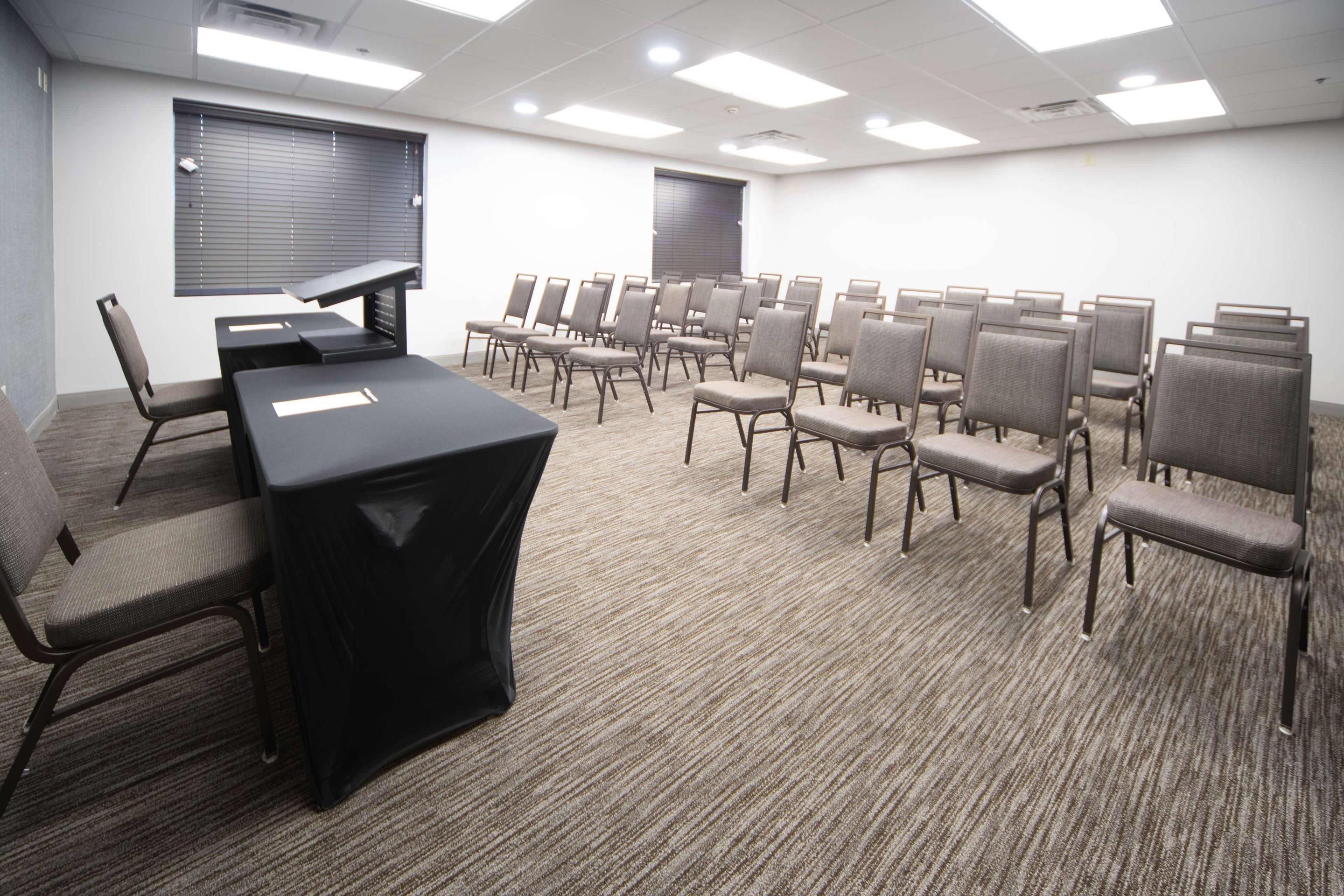 A conference room with a long table and multiple chairs arranged for meetings.