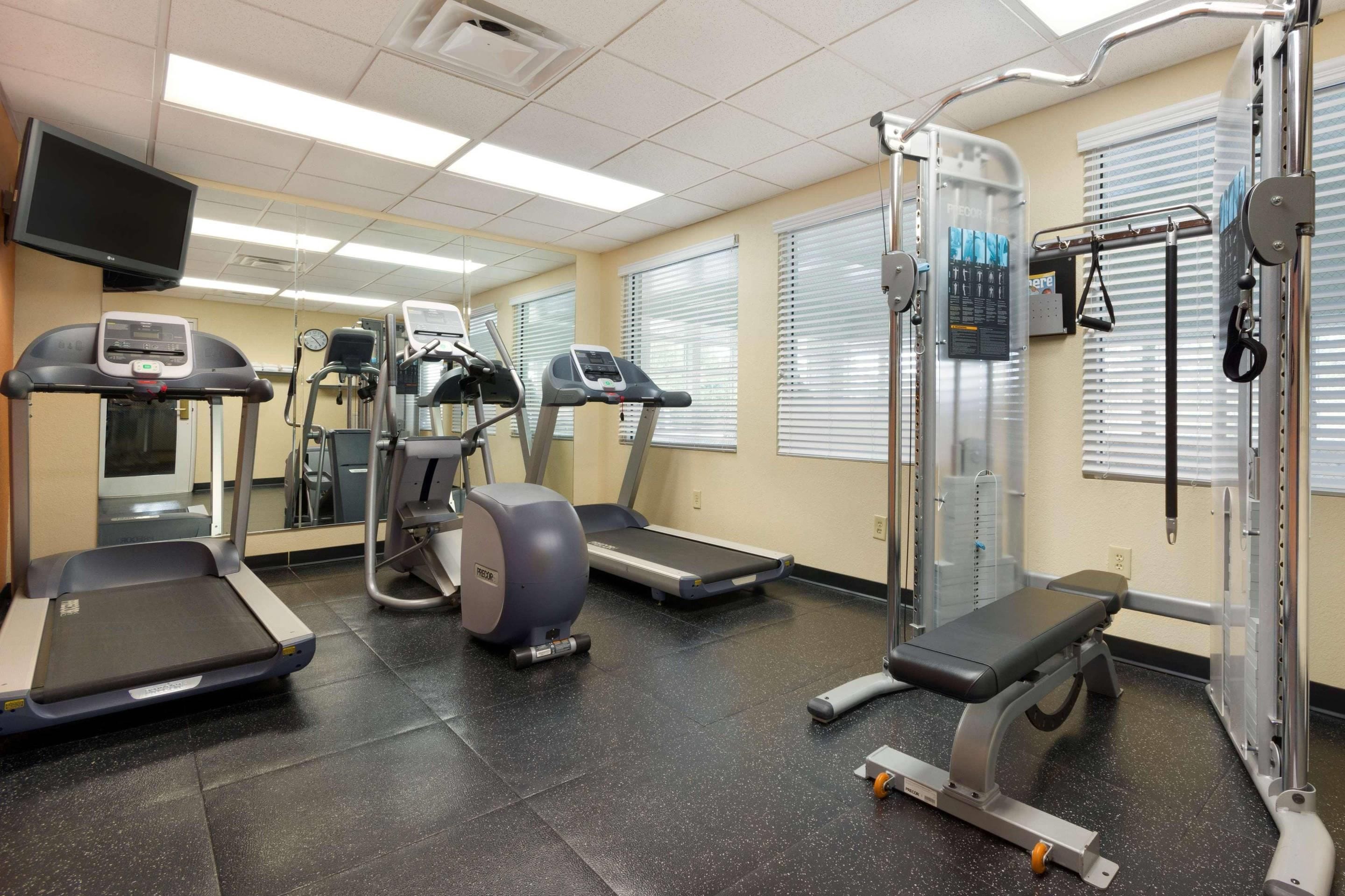 A fitness center with treadmills, elliptical machines, and a weightlifting area.