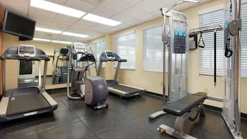 A fitness center with treadmills, elliptical machines, and a weightlifting area.