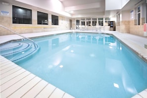 An indoor swimming pool with clear water, a pool ladder, and a tiled deck. - Country Inn & Suites by Radisson, Stone Mountain, GA (Stone Mountain)
