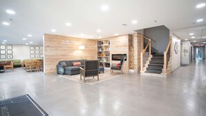 A spacious lobby with a modern design, featuring a sofa, chairs, a staircase, and a reception area. - Country Inn & Suites by Radisson, Stone Mountain, GA (Stone Mountain)