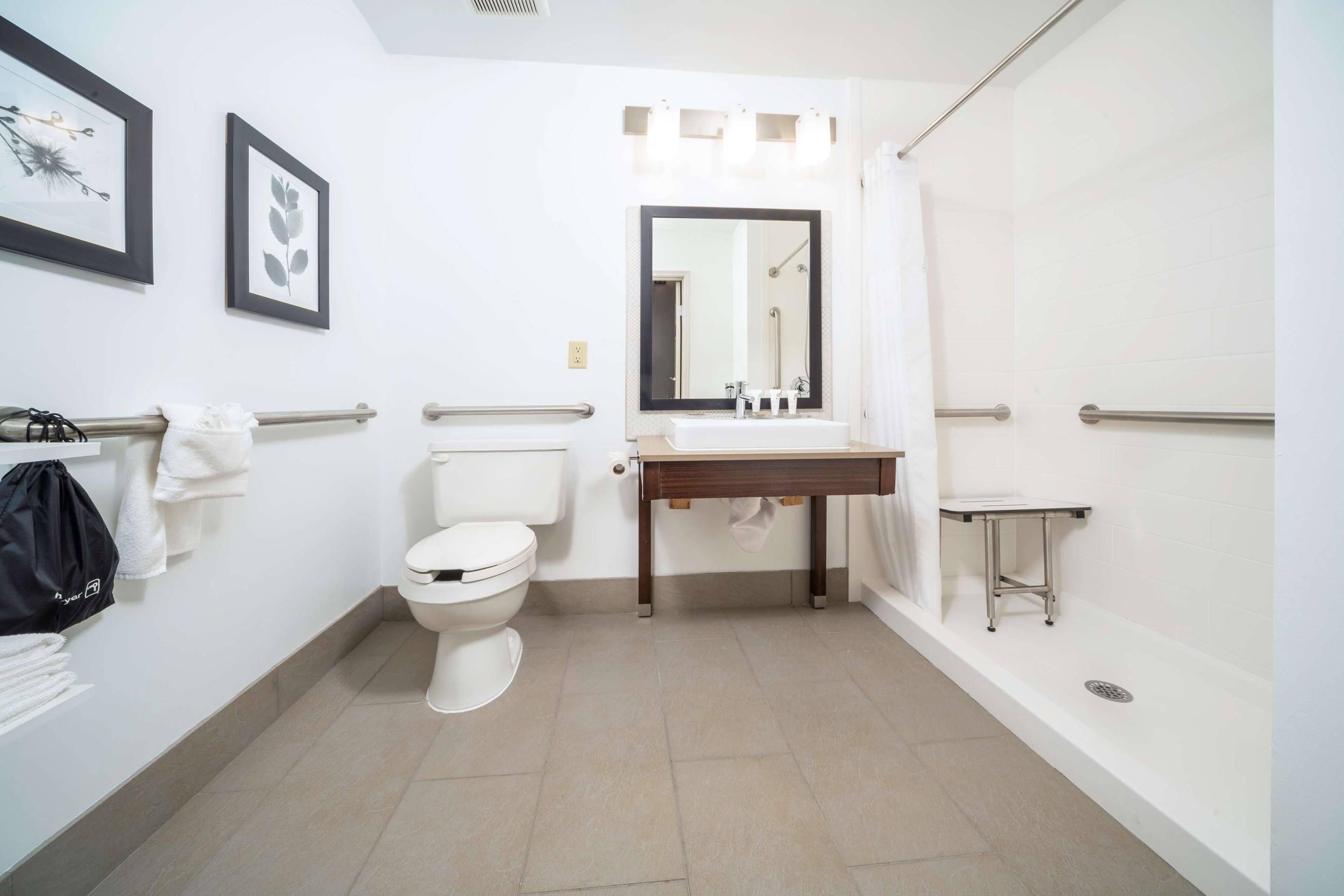 Un baño moderno con inodoro, lavamanos y ducha.