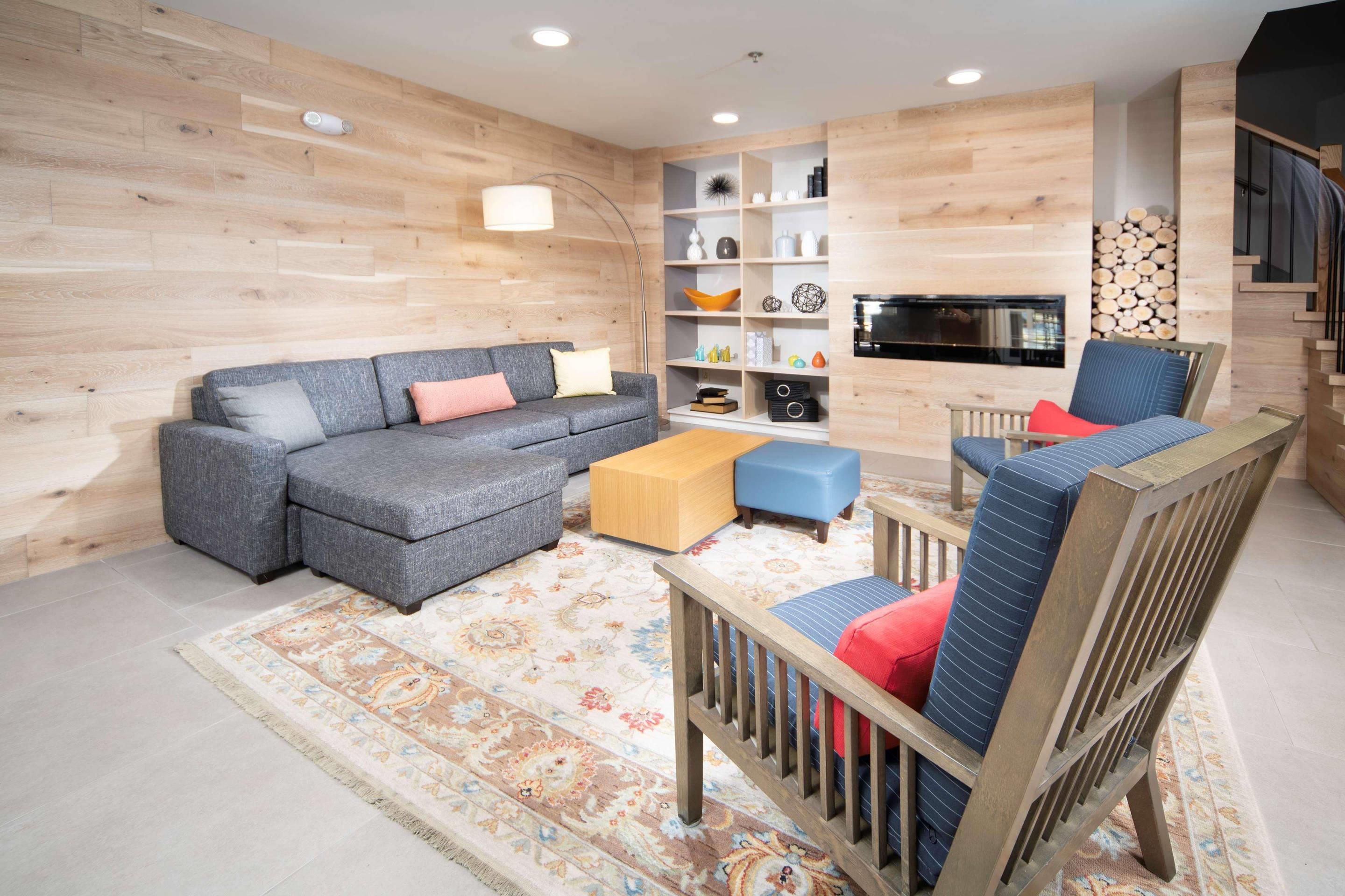 A modern living room with a sectional sofa, a wooden coffee table, and a patterned rug.